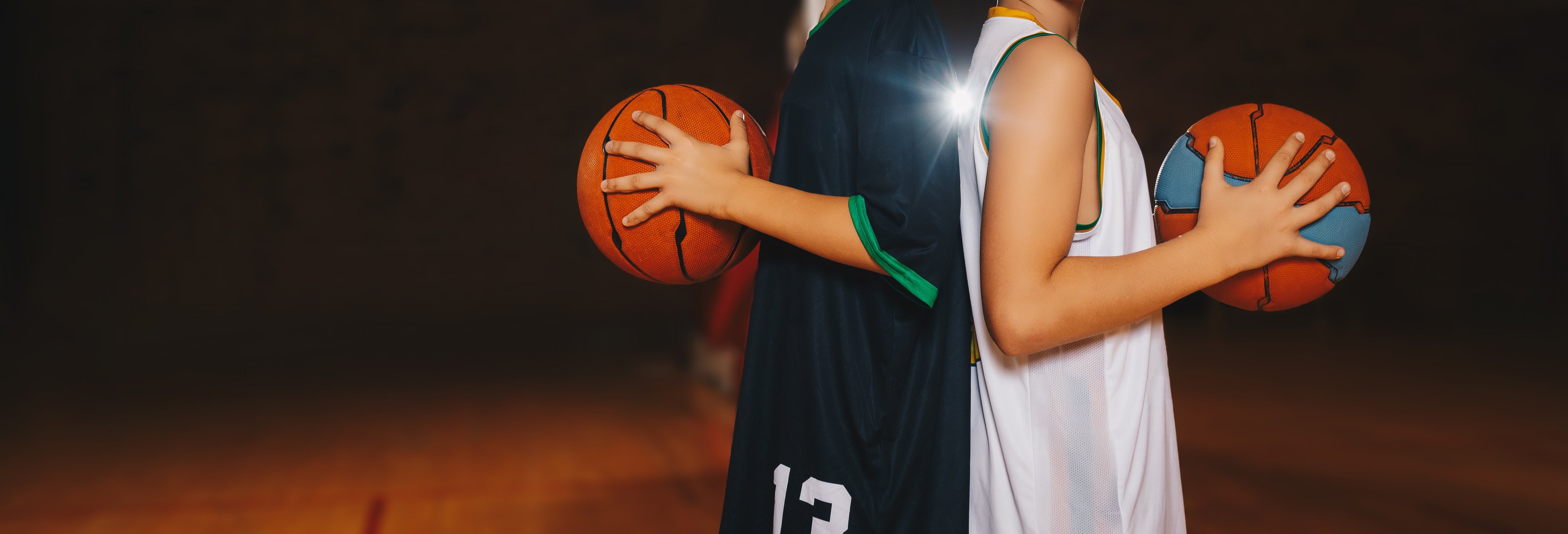 Two Boys Basketball Team Players Holding Basketballs on the Wood